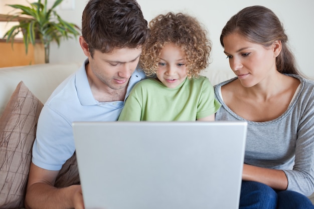 Foto familia usando una computadora portátil