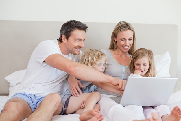 Familia usando el cuaderno en la cama