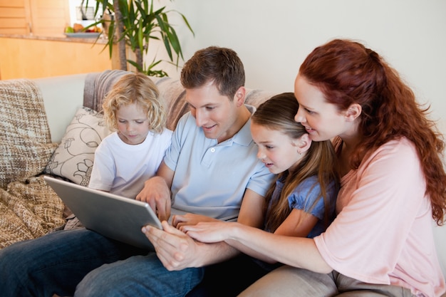 Familia usando el cuaderno en el sofá