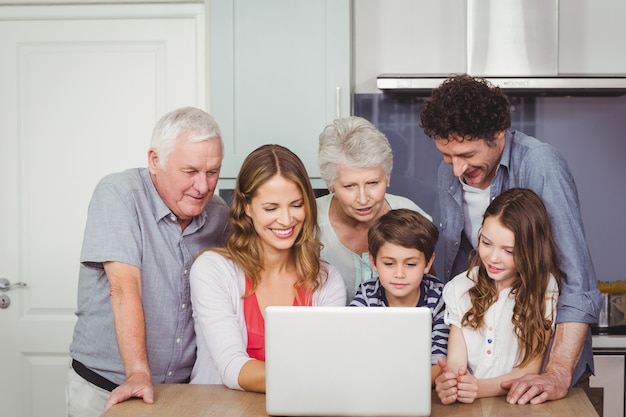 Família usando laptop na cozinha