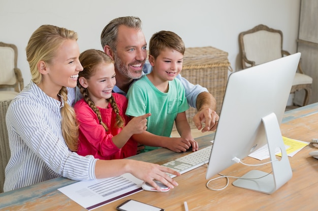 Foto família usando o computador em casa