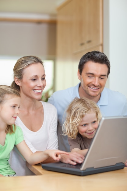 Família usando o laptop na cozinha