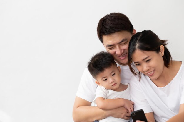 Foto familia usando el teléfono móvil contra un fondo blanco