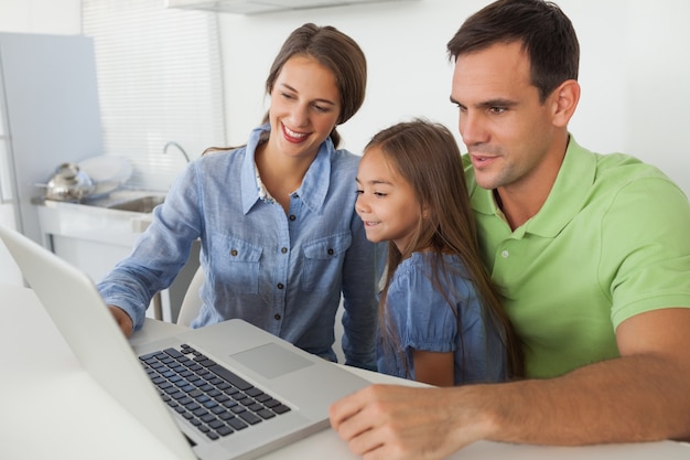 Foto família usando um laptop na cozinha