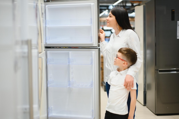 Familia uying refrigerador doméstico en supermercado