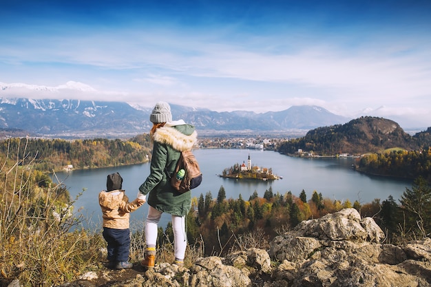 Família viaja pela europa mãe com filho olhando para o lago bled outono ou inverno na eslovênia europa