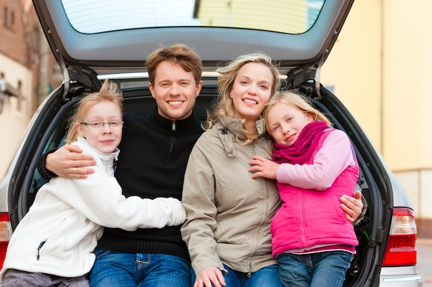 Familia en un viaje en auto sentada en la parte de atrás