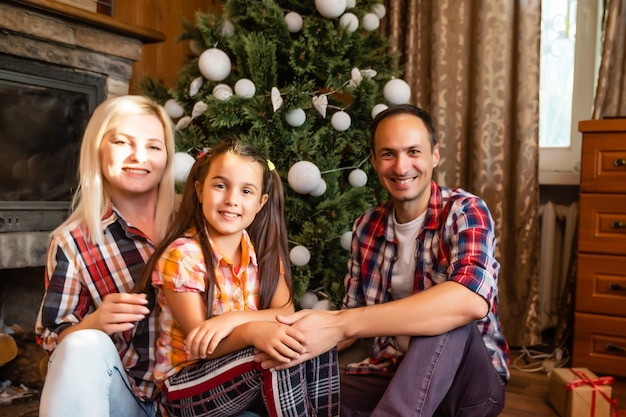 Familia en una vieja casa de madera. Hermosas decoraciones navideñas. El ambiente festivo. Vacaciones navideñas.