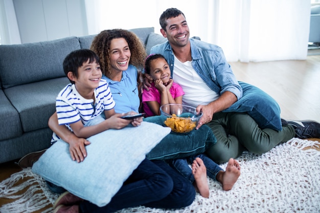 Familia viendo un partido de fútbol americano en la televisión