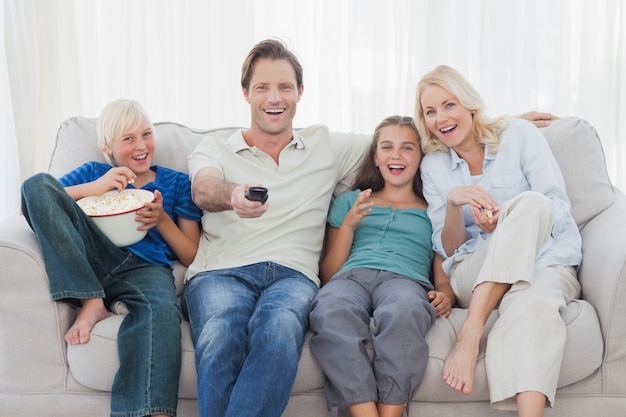 Familia viendo la televisión sentado en el sofá