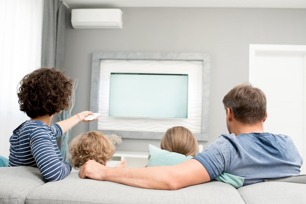 Familia viendo televisión, vista posterior