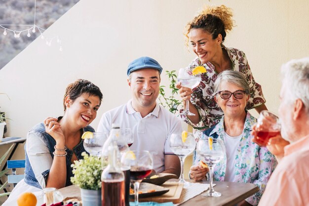 Familiares y amigos almorzando todos juntos en casa en la terraza