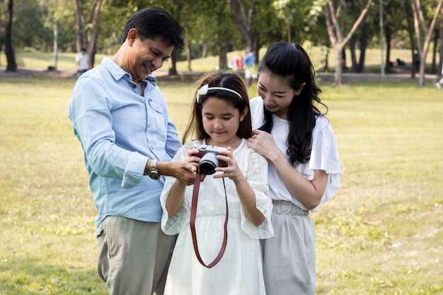 Famílias asiáticas assistindo fotos de suas câmeras.