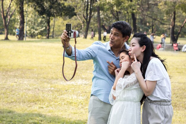 Las familias asiáticas están tomando fotos familiares en un parque público.