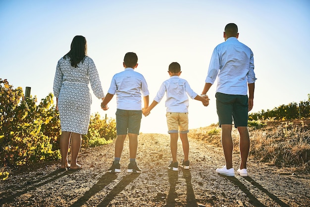 Foto las familias permanecen unidas para siempre sin importar lo que suceda toma de vista trasera de una familia uniéndose al aire libre