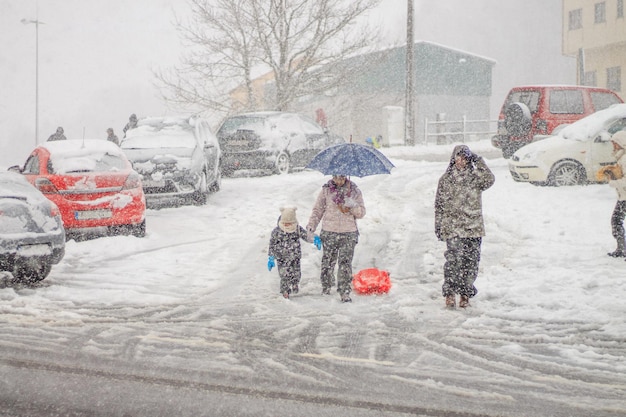 Familie auf der Straße unter dem Schnee.