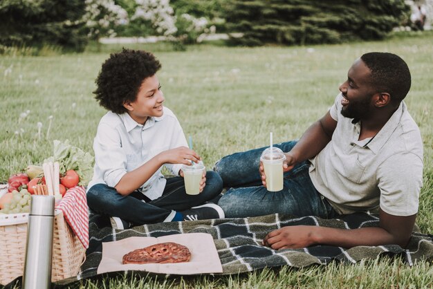 Familie auf Picknick und trinkendem Saft zusammen