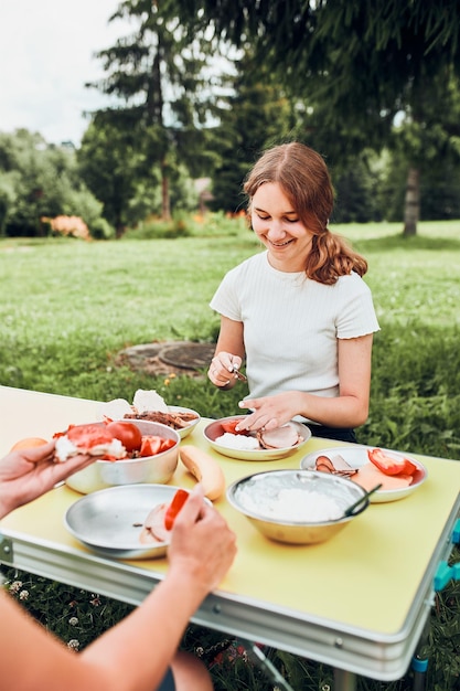 Foto familie beim frühstück im freien beim campen während der sommerferien