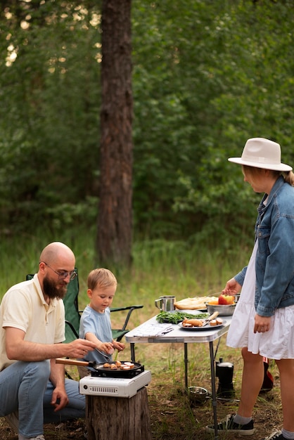 Familie bereitet abendessen beim camping vor