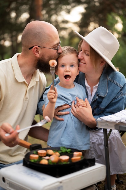 Foto familie bereitet abendessen beim camping vor