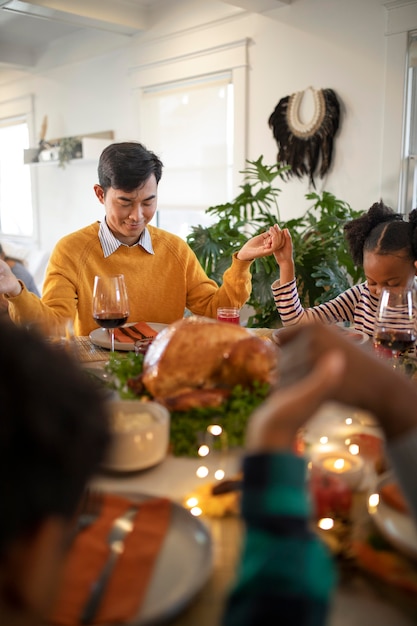 Foto familie betet zusammen vor dem thanksgiving-dinner