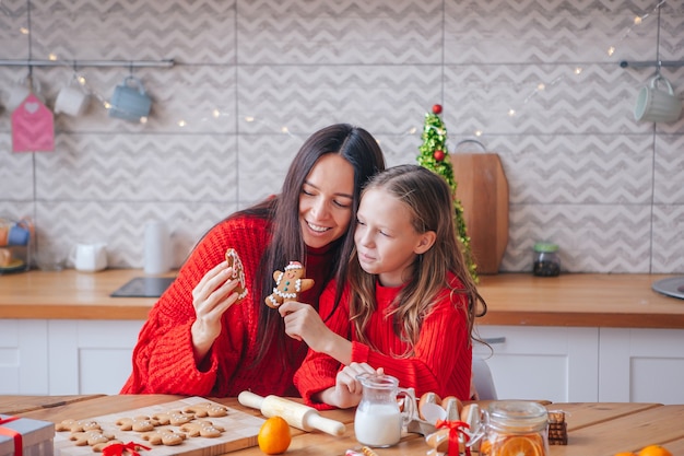 Familie der Mutter und der kleinen Tochter, die Weihnachtsplätzchen zu Hause zusammen kochen. Frohe Weihnachten und schöne Feiertage.