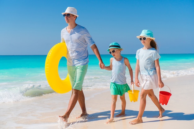 Familie des Vatis und der Kinder, die auf weißen tropischen Strand auf Karibikinsel mit Strand gehen, spielt. Familienurlaub am Strand