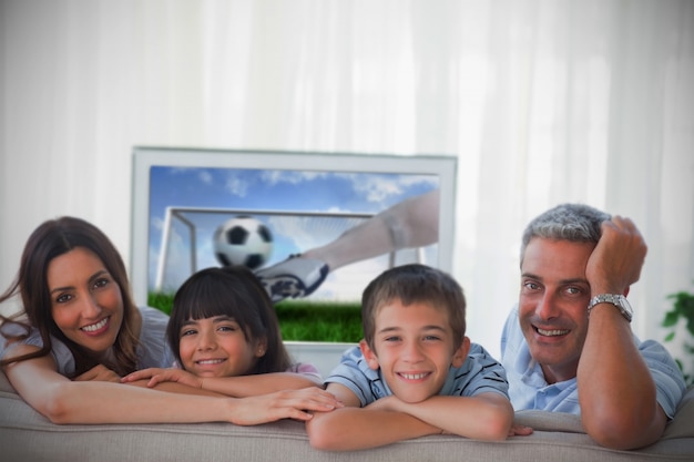 Familie, die an der Kamera mit dem Weltcup zeigt im Fernsehen lächelt
