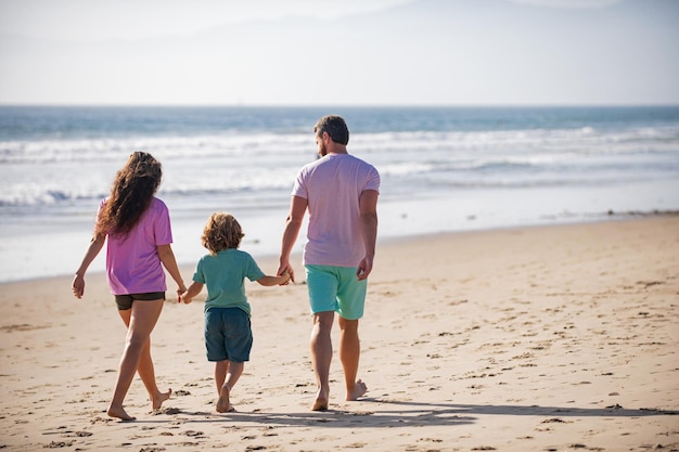 Familie, die an einem sonnigen Tag zum Strand geht