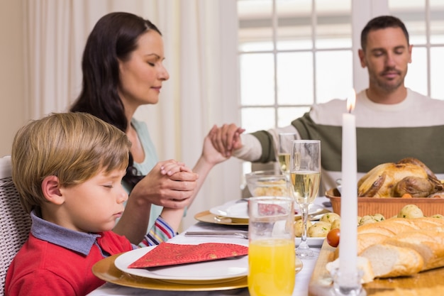 Familie, die Anmut vor Weihnachtsessen sagt