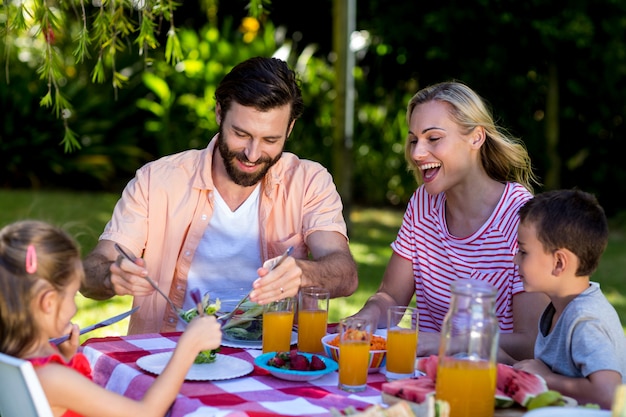 Familie, die bei Tisch Frühstück im Yard genießt