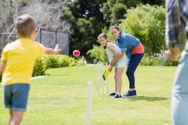 Familie, die Cricket im Park spielt