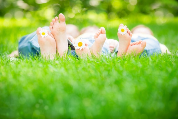 Familie, die draußen im Frühlingspark auf Gras liegt