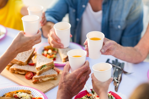 Familie, die ein Picknick und ein Rösten hat