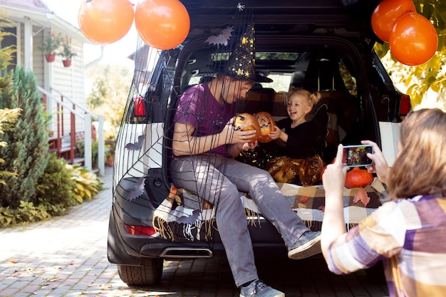 Familie, die halloween-autokofferraum feiert, der spaß zusammen im herbst hat