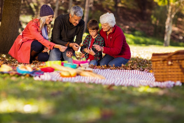 Familie, die Herbstlaub am Park hält