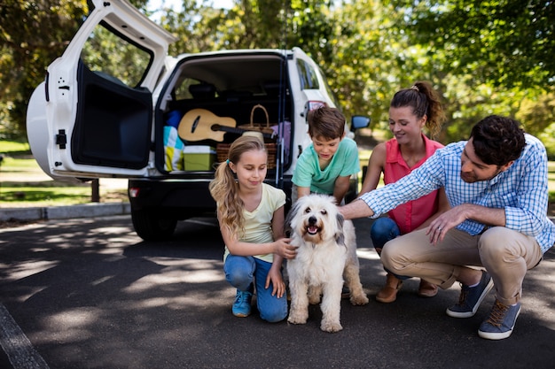 Familie, die im Park mit ihrem Hund sitzt