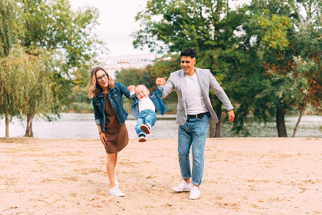 Familie, die im Park zusammen nahe einem See spielt