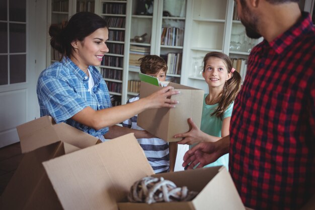 Familie, die Kartonboxen zusammen auspackt