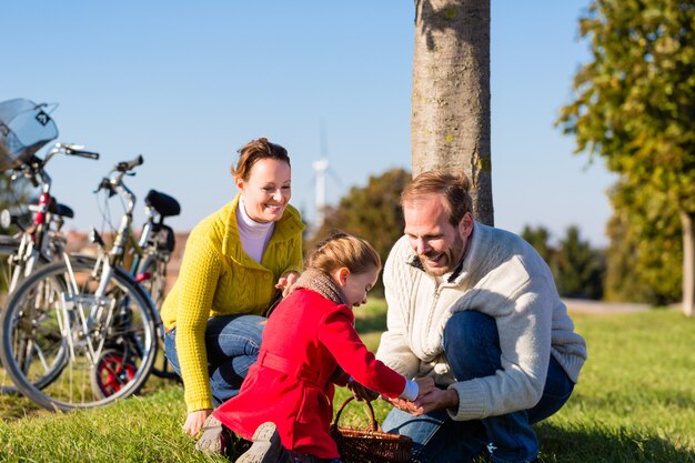 Familie, die Kastanien auf Fahrradreise sammelt