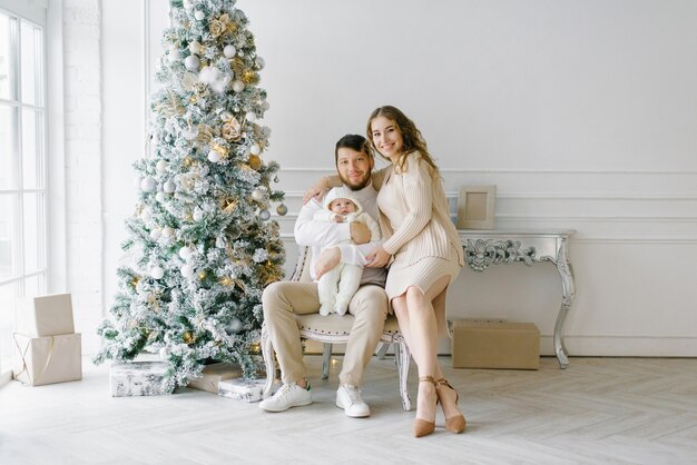 Familie, die nahe dem Weihnachtsbaum aufwirft