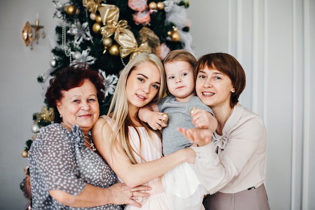 Familie, die nahe dem Weihnachtsbaum aufwirft