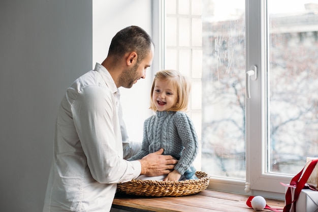 Familie, die nahe Fenster spielt. Familienkonzept.