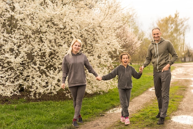 familie, die spaß mit blühendem baum im blühenden frühlingsgarten hat.