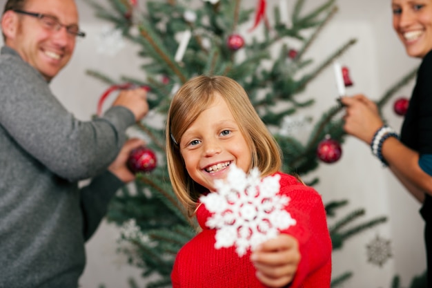 Familie, die Weihnachtsbaum verziert