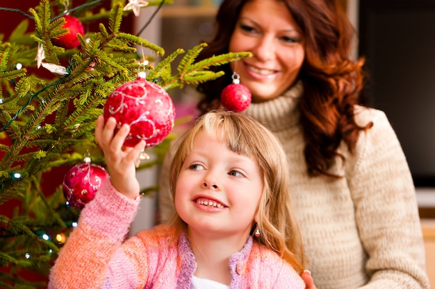 Familie, die Weihnachtsbaum verziert