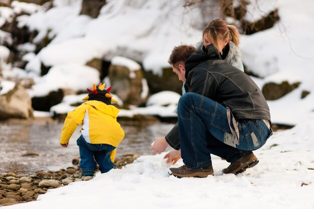 Familie, die Winterweg in Fluss hat