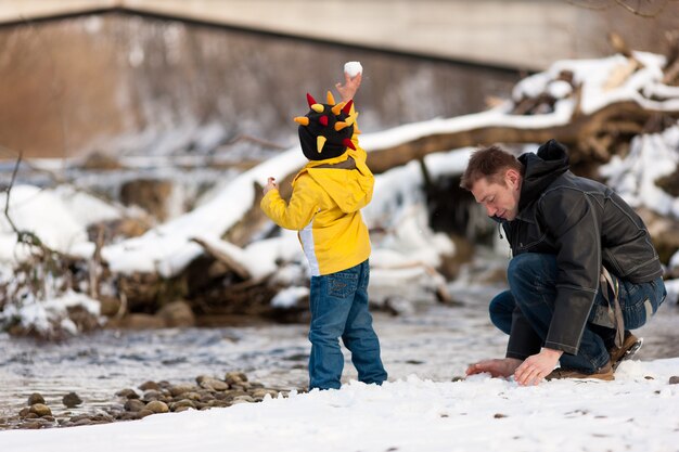 Familie, die Winterweg in Fluss hat