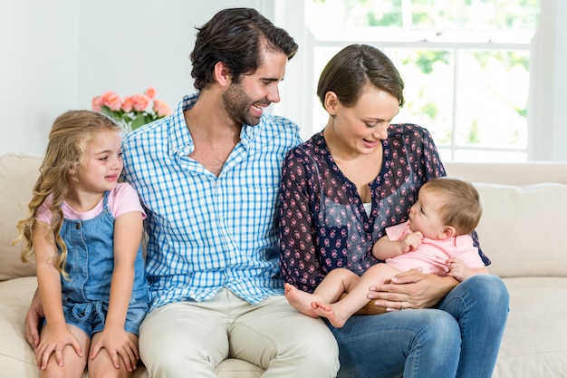 Familie, die zu Hause auf Sofa sitzt