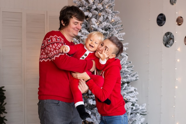 Familie, die zu Hause nahe Weihnachtsbaum spielt Weihnachtsgeschenke im Hintergrund.